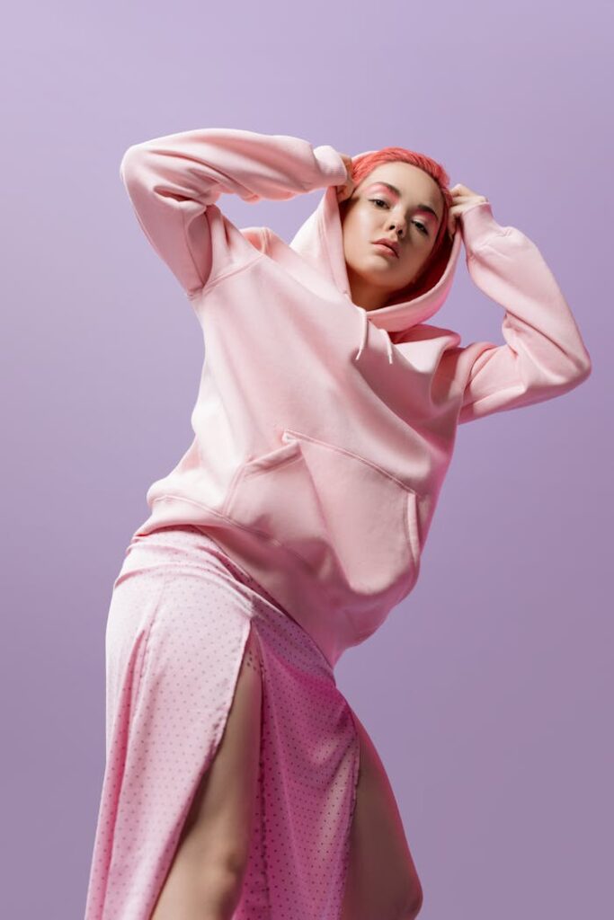 A Low Angle Shot of a Woman in Pink Hoodie Looking with a Serious Face